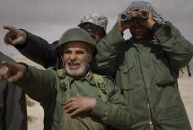 Combatientes libios observan la línea del frente a las afueras de la ciudad de Ajdabiya