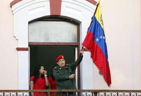 El presidente Hugo Chávez ondea la bandera de Venezuela tras salir al denominado Balcón del Pueblo del Palacio de Miraflores para saludar a miles de simpatizantes que le recibieron con una estruendosa ovación