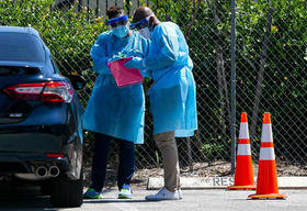 Laboratoristas realizan una prueba diagnóstico de coronavirus a dos personas que llegaron en su auto a un estacionamiento de FoundCare en West Palm Beach, el 17 de marzo de 2020