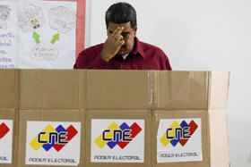 El presidente de Venezuela y candidato a las elecciones, Nicolás Maduro, se santigua antes de emitir su voto