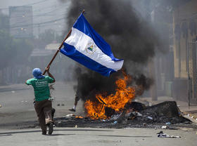 Un joven corre con una bandera en Masaya, Nicaragua, durante una serie de disturbios