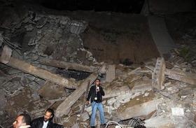 Un periodista informa desde los escombros a los que quedó reducido un edificio administrativo del líder libio Muamar el Gadafi, tras el impacto de un misil