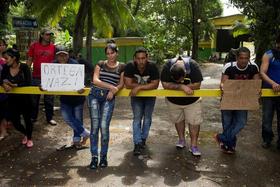 Inmigrantes cubanos muestran un cartel en contra del presidente nicaragüense Daniel Ortega