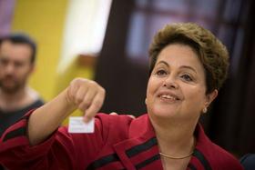La presidenta de Brasil Dilma Rousseff, muestra el comprobante que indica que ya emitió su voto electrónico en Porto Alegre, Brasil, el domingo 5 de octubre de 2014