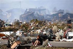 Una mujer llora sentada en una carreta en medio de la destruida ciudad de Natori, en la Prefectura de Miyagi en el norte de Japón, el 13 de marzo de 2011
