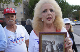 Clara Roteta, a las afueras del encuentro de Donald Trump con miembros de la Brigada 2506, con una foto de su padre que participó en la invasión de Bahía de Cochinos (foto: Univisión)