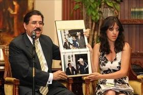 El presidente de Honduras y su hija muestran fotografías de su encuentro con Fidel Castro, 12 de marzo de 2009. 