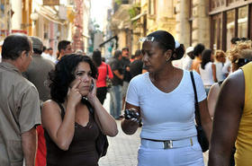 Cubana habla por un teléfono celular en la ciudad de La Habana