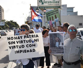 Varios cubanos sostienen carteles con fotos de Guillermo Fariñas y banderas cubanas durante una vigilia realizada el miércoles 27 de julio 2016, frente al Restaurante Versailles en Miami, Florida