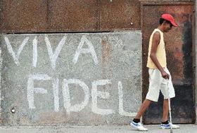 Un hombre camina en La Habana junto a un cartel alusivo al ex gobernante cubano Fidel Castro, que cumple hoy viernes 84 años