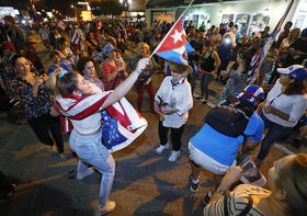 Exiliados cubanos bailan en la Calle Ocho de Miami, junto al restaurante Versailles, el 26 de noviembre, celebrando la muerte de Fidel Castro