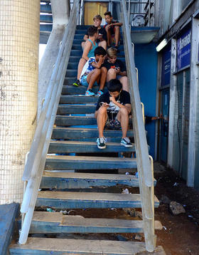 Un grupo de adolescentes navega por Internet sentados en las escaleras del Hotel Habana Libre. (Foto: Rui Ferreira.)