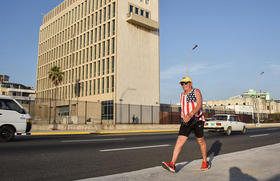 Un hombre, que lleva una playera con la bandera estadounidense, camina a las afueras de la Embajada de EEUU en La Habana