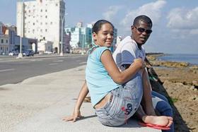 Richard, un joven guantamero, sentado junto a su novia en el Malecón de La Habana