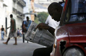 Un cubano lee un periódico en La Habana