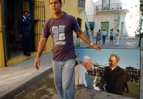 Un cubano transporta una foto del fallecido papa Juan Pablo II con Fidel Castro
