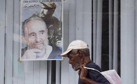 Un cubano pasa junto a un cartel dedicado al cumpleaños de Fidel Castro