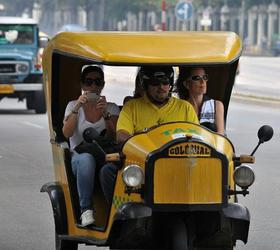 Tres turistas viajan en un Cocotaxi, el martes 25 de octubre, en La Habana