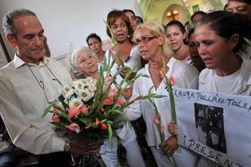 Héctor Maseda (i), viudo de Laura Pollán, y varias integrantes de las Damas de Blanco rezan por su fallecida líder el domingo 16 de octubre de 2011, en La Habana