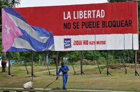 Un hombre barre la calle el martes 25 de octubre de 2011, en La Habana, junto a un cartel alusivo al embargo de Estados Unidos contra el Gobierno cubano