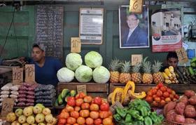 Dos jóvenes esperan la llegada de clientes en un agromercado en La Habana