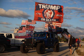 Robert Fix muestra su apoyo a Donald Trump con un enorme estandarte que expresa «Trump o muerte», cerca de Mar-a-Lago el 20 de marzo de 2023
