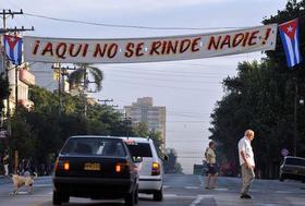 Varias personas caminan junto a un cartel de contenido revolucionario el sábado 24 de diciembre de 2011, en La Habana. (EFE)