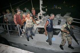 Inmigrantes cubanos apresados en Cancún, México, son escoltados por miembros de la marina de guerra mexicana, en esta fotografía del 6 de junio de 2008