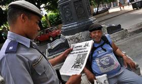 Un miembro de la policía cubana mira el periódico Granma en la Habana, con la noticia de la muerte del Comandante de la Revolución Juan Almeida Bosque, el 12 de septiembre de 2009