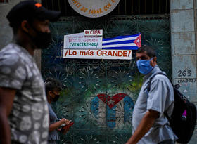 Varias personas caminan frente a una bandera de Cuba en La Habana, el 11 de noviembre de 2021