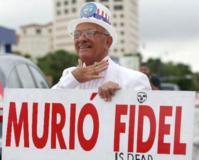 Un exiliado cubano en Miami con un cartel anunciando la muerte de Fidel Castro, el día que se anunció que éste no aspiraría de nuevo a la presidencia de Cuba