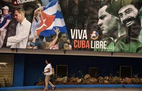 Mujer pasa junto a cartel revolucionario en Cuba