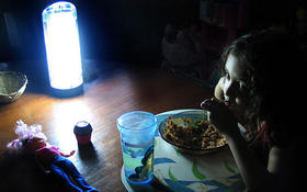 Una niña come alumbrada por una lámpara de baterías durante un apagón en Cuba, en esta imagen de archivo