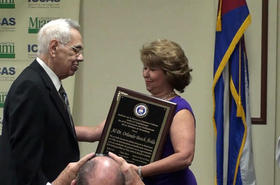 Carmen Toro de Gómez presenta una placa de reconocimiento a Orlando Bosch, durante un evento patrocinado por El Instituto de la Memoria Histórica Cubana Contra el totalarismo