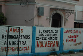 Consignas revolucionarias pintadas en un muro deteriorado en La Habana