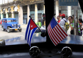 Fotografía de archivo, del 22 de marzo de 2013, de dos pequeñas banderas de Cuba y Estados Unidos sobre el tablero de instrumentos de un automóvil en La Habana, Cuba