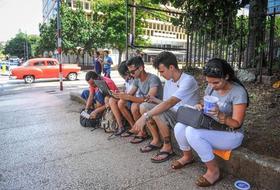 Jóvenes cubanos utilizan computadores y teléfonos móviles (celulares) en Cuba