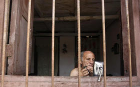 Un hombre se afeita utilizando un espejo de auto. La Habana, 4 de junio de 2009. (REUTERS)