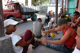 Un grupo de jóvenes amigos celebra compartiendo una botella de ron en Santiago de Cuba