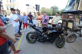 Un hombre exhibe orgullosamente, en una esquina del Parque Central, una moto de último modelo que ha importado. (Foto: Rui Ferreira.)